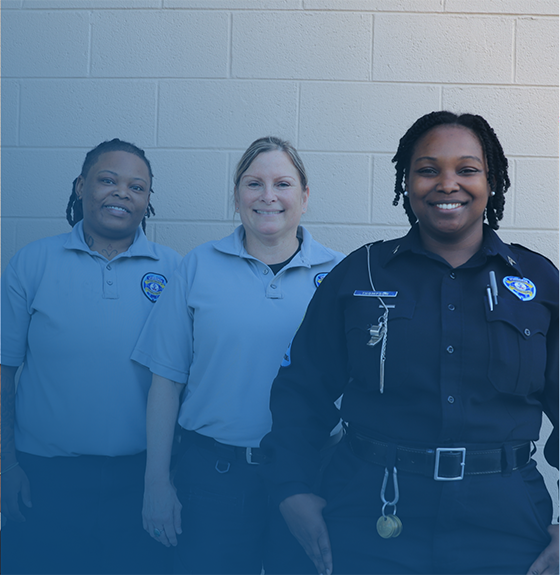 Three lady corrections officers standing.